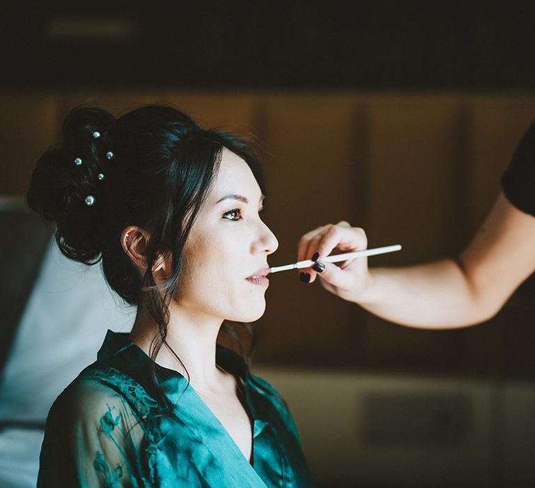 Bride has her eye makeup done on her wedding day