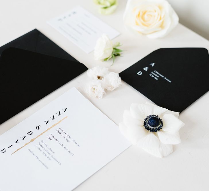 Black and white wedding stationery with gold details. The invitation is white and the envelope is black.