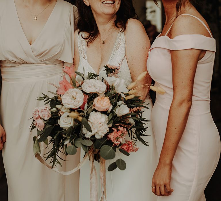 Bride with bridal party in blush bridesmaid dresses