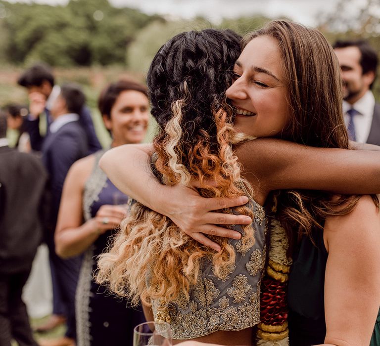 Bride hugs wedding guest outdoors after ceremony | Joshua Gooding Photography