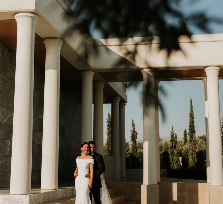 Bride & groom stand beside white pillars at the Villa 20 on their wedding day | Hannah MacGregor Photo & Film