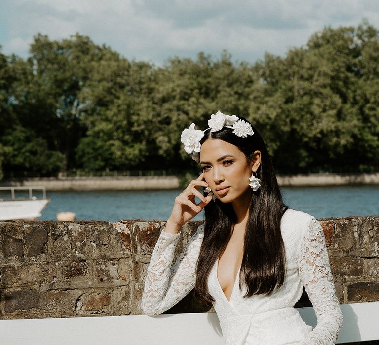 Bride with long hair wearing a flower crown and lace long sleeve wrap wedding dress