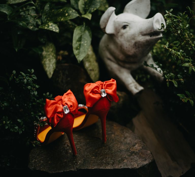 Red satin heeled sandals with bow at rustic wedding in Lancashire