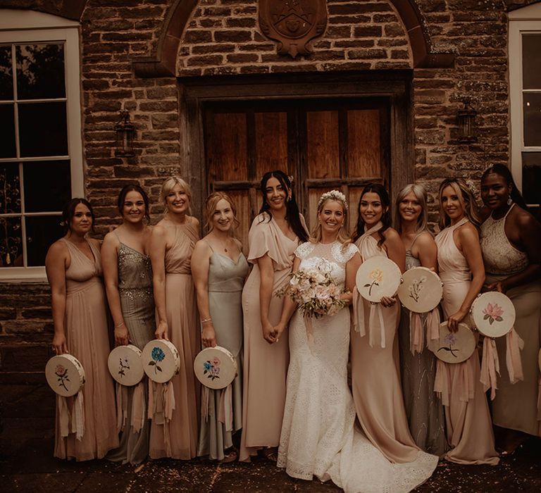 Bridal party portrait with bridesmaids in different dresses holding tambourines instead of bouquets 