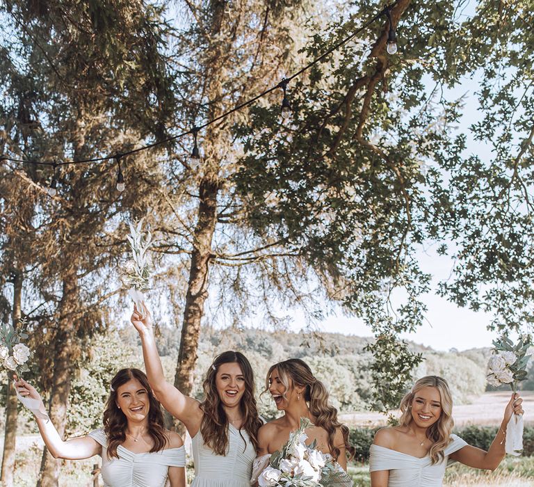 Bride laughs with her bridesmaids on her wedding day