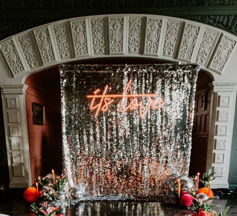 Retro Aisle wedding decor with silver sequin curtain, neon sign, red tulip bouquet and aisle wedding flowers 