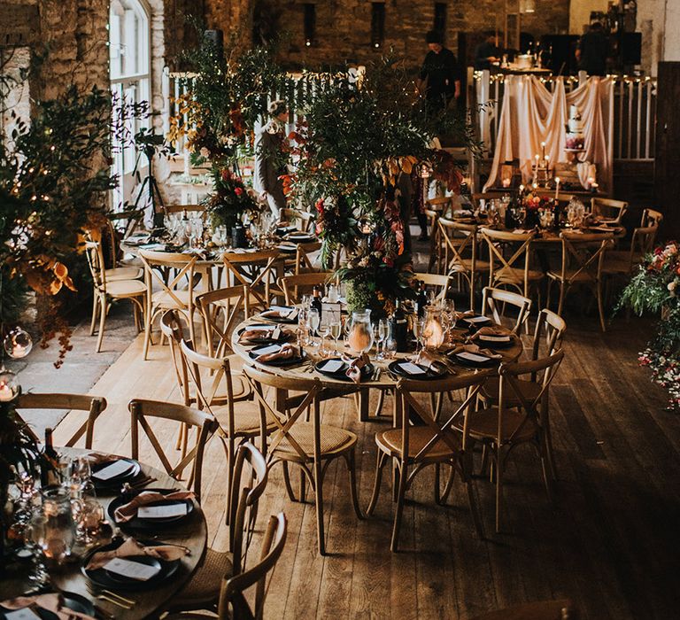 Woodland, autumn theme wedding at Askham Hall with tree centrepieces, string lights, taper candles and pumpkins decor 