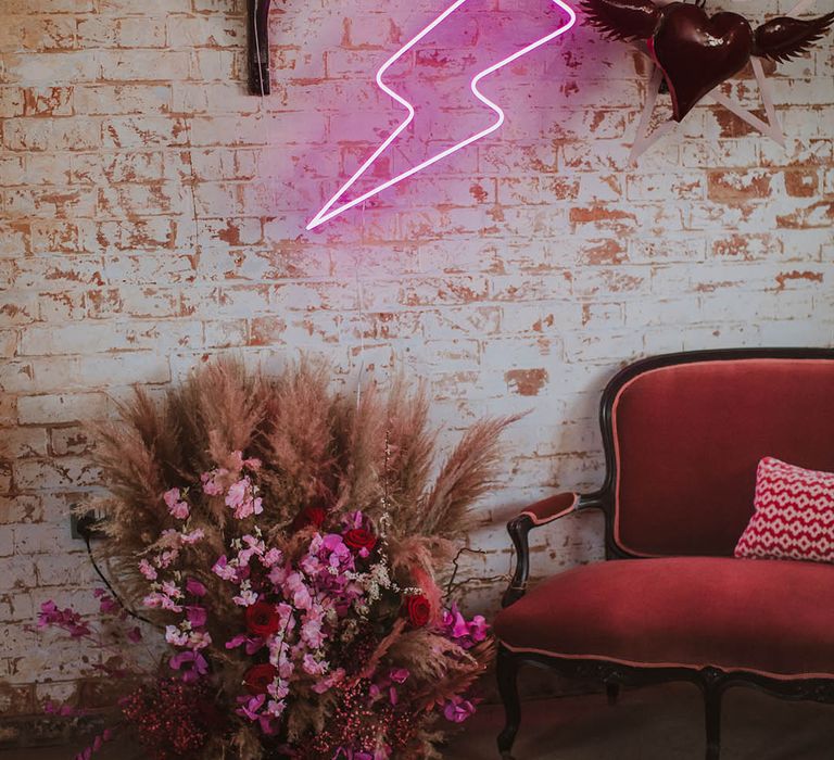 Pink velvet couch, pink neon lightning sign and quirky heart wedding decor at Prestwold Hall Barn 