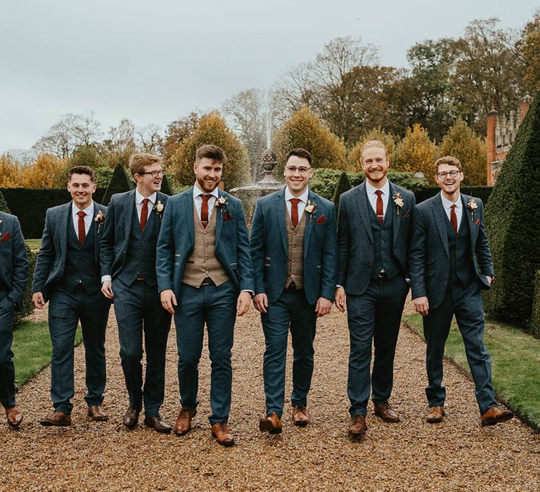 Groom with groomsmen in blue suits and orange ties for the autumn wedding 