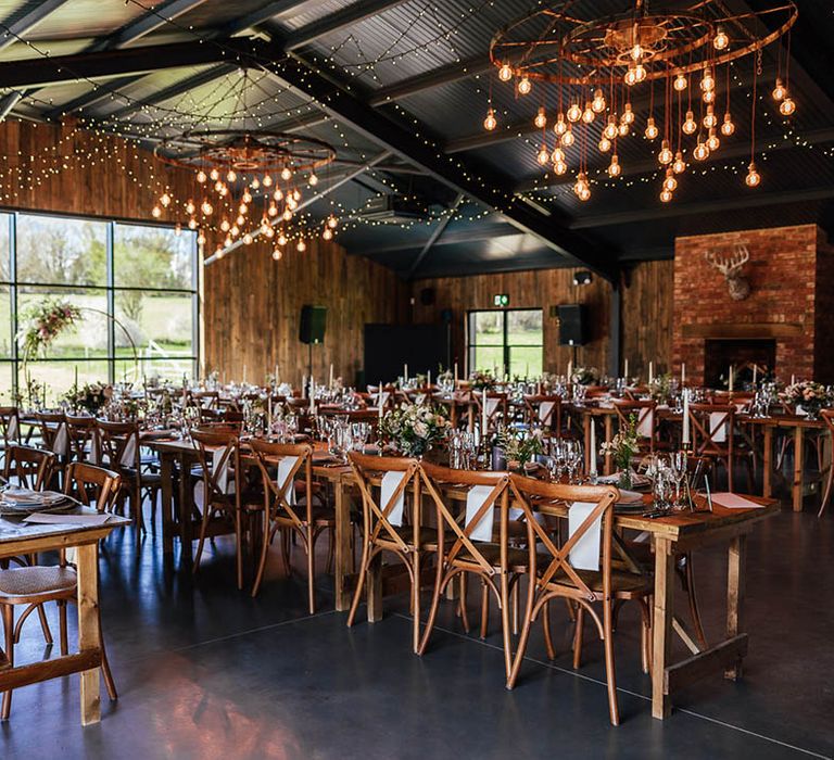 Rustic barn wedding venue with festoon lighting and pink florals 