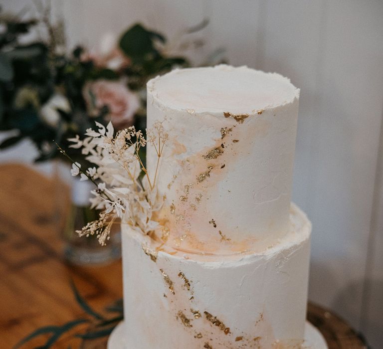 Two tier wedding cake with pink and gold detail with pampas grass decoration 