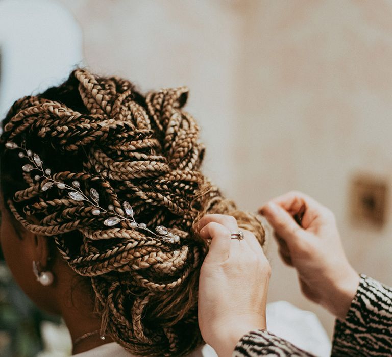 Bride gets her hair styled for her wedding day with a silver and jewelled wedding hair accessory 