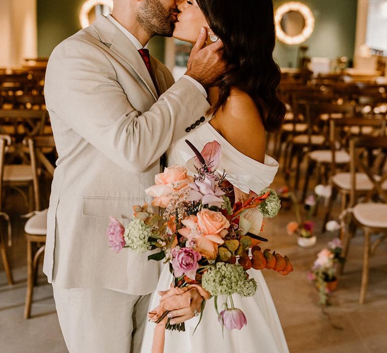 Bride and groom share their first kiss as a married couple for their autumnal wedding 