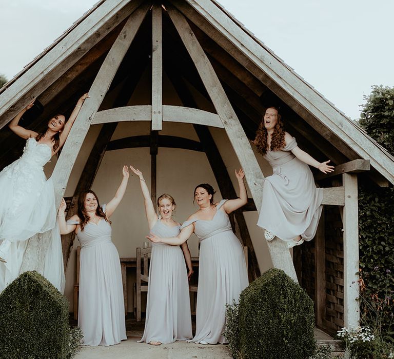 Bridal party shot with bridesmaids in grey off the shoulder dresses and bride in strapless flower gown 