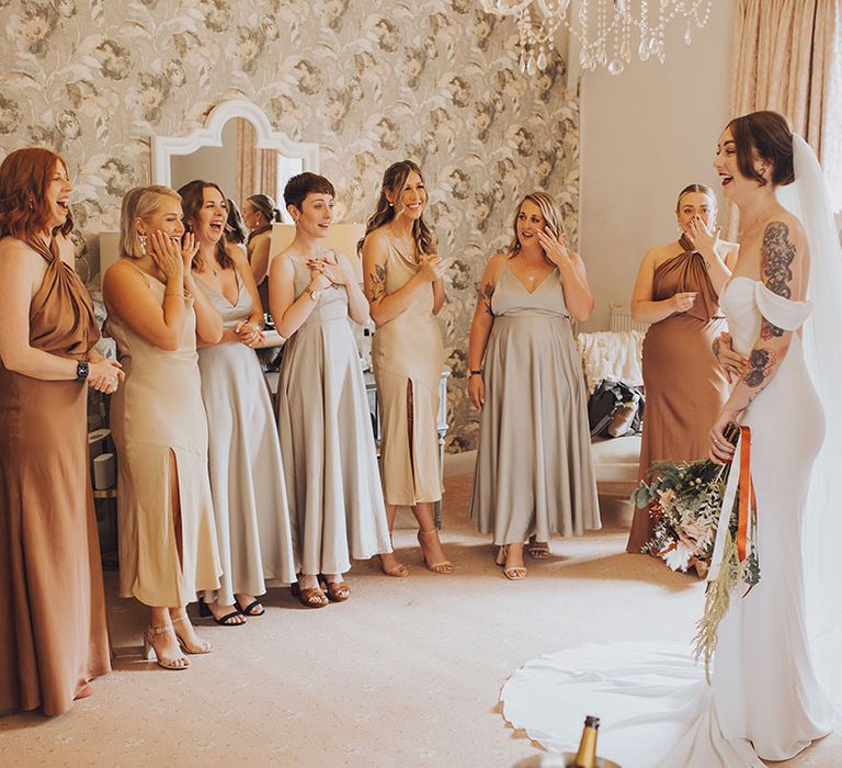 Bridesmaids in mismatched bridesmaid dresses and different colouring see their bride for the first time 