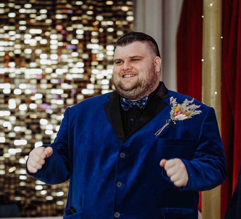 Groom in midnight blue blazer, black shirt with galaxy patterned bowtie and autumnal boutonniere