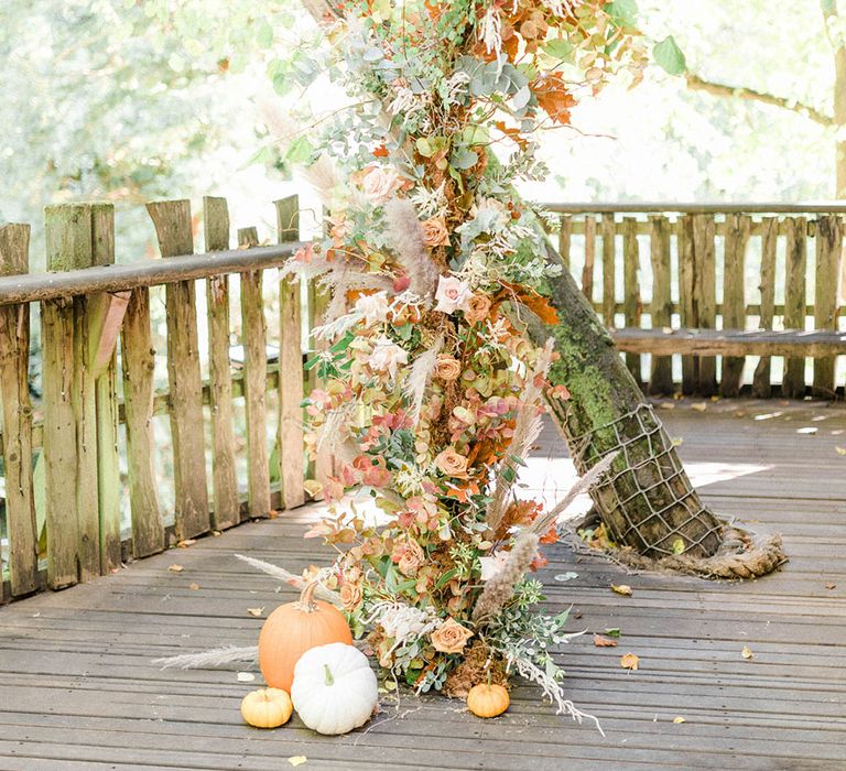 Dried floral column beside tree complete with pumpkin decor to the bottom at Alnwick Garden Treehouse