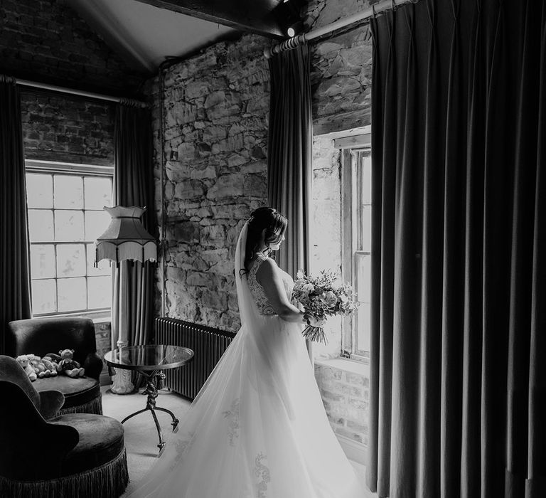 Bride wears lace wedding dress complete with lace embellished cathedral veil 