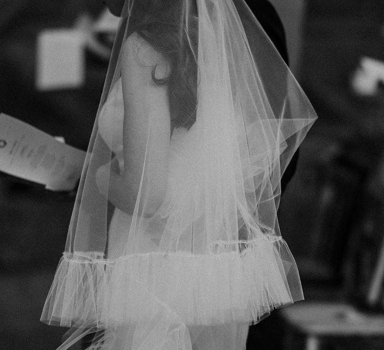 Bride wearing a cathedral length ruffle wedding veil 