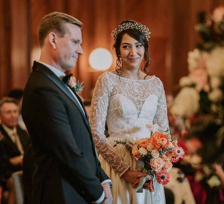 Bride and groom standing at the alter of multicultural Christmas wedding with a Lion Dance and disco decorations