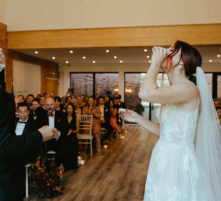 Bride & groom do tequila shot during their wedding ceremony 