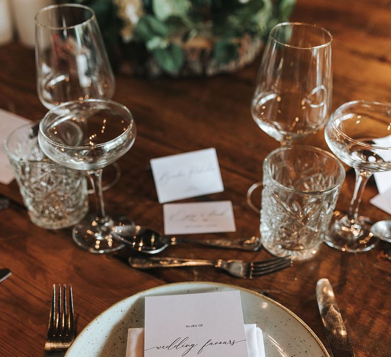 Black and white wedding menu and napkin on duck egg speckled plate with silver cutlery and crystal glassware 