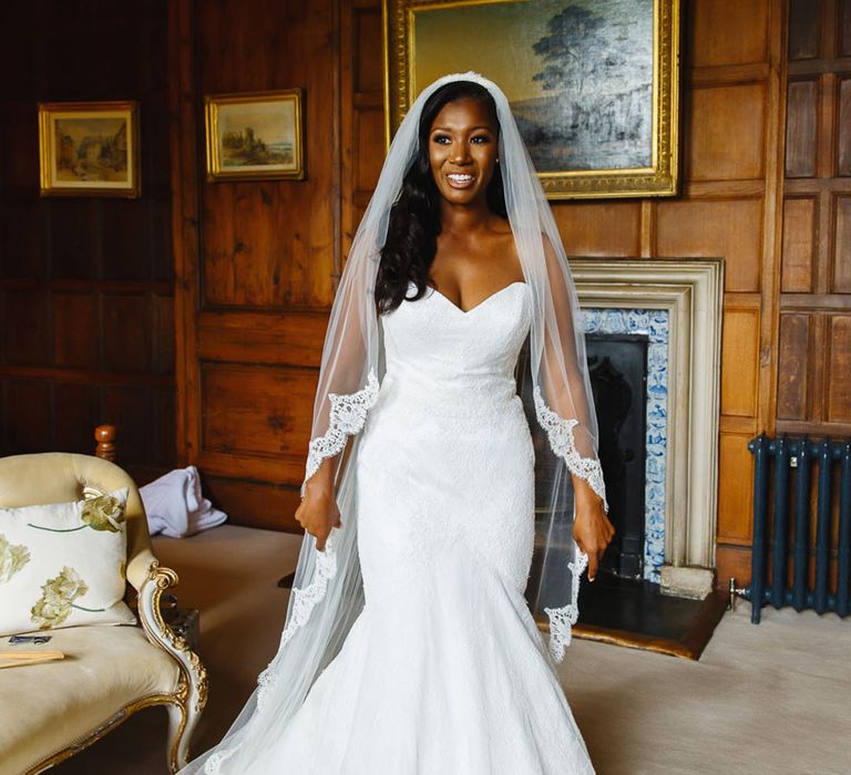 Black bride in a sweetheart mermaid wedding dress with an embroidered edge veil 