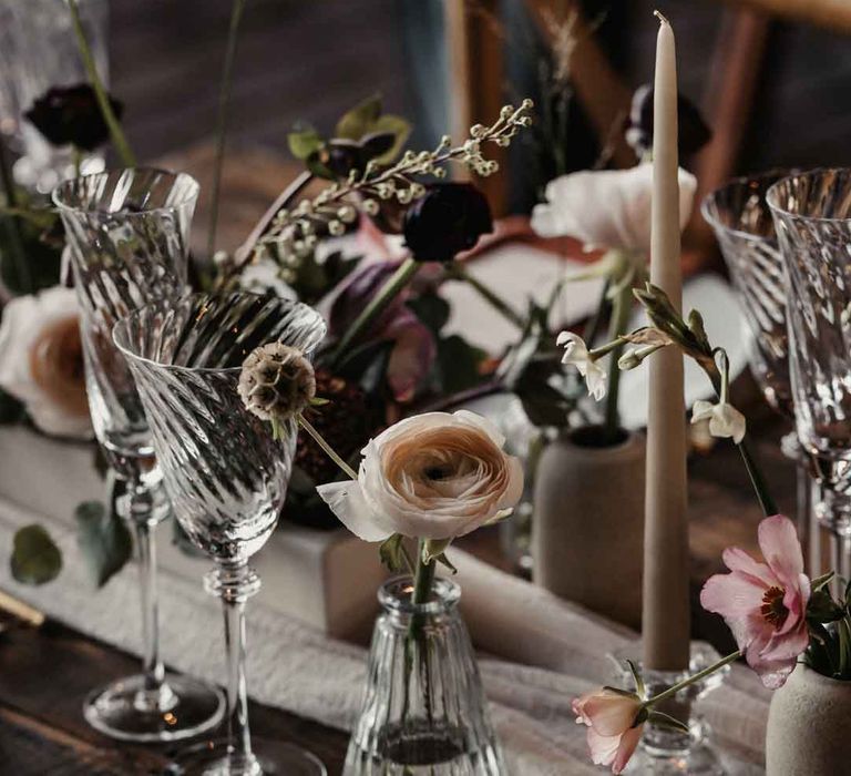 Modern rustic luxe wedding tablescape with white cloth table runner, delicate glasses and tapered candles 