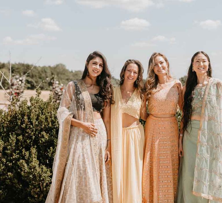 Wedding guests in colourful traditional Indian lehengas at Gujarati wedding ceremony