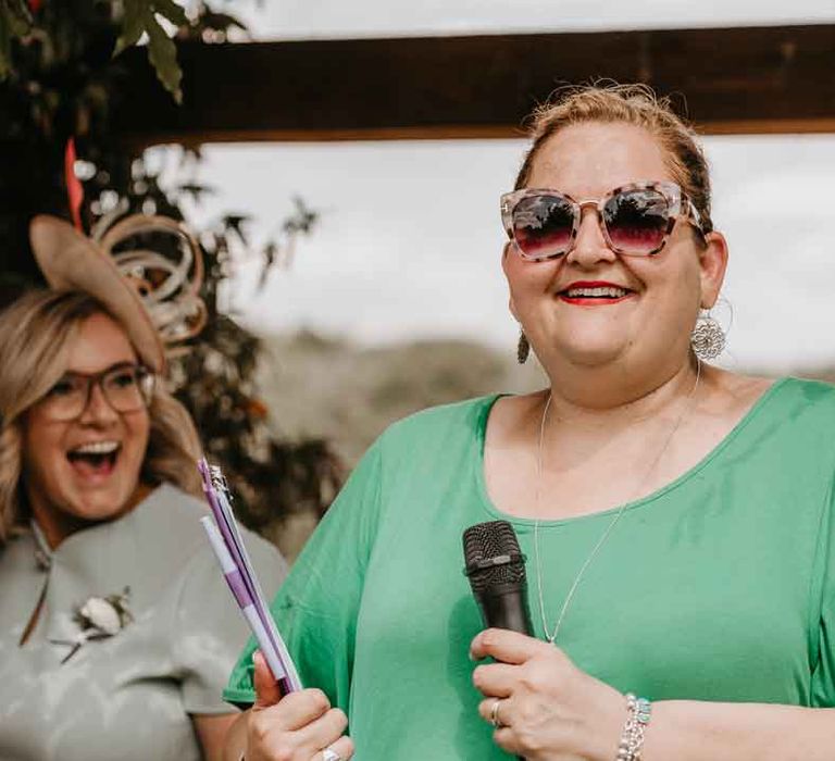 Wedding MC in green top and sunglasses doing wedding speeches for Gujarati wedding ceremony at High Billinghurst Farm