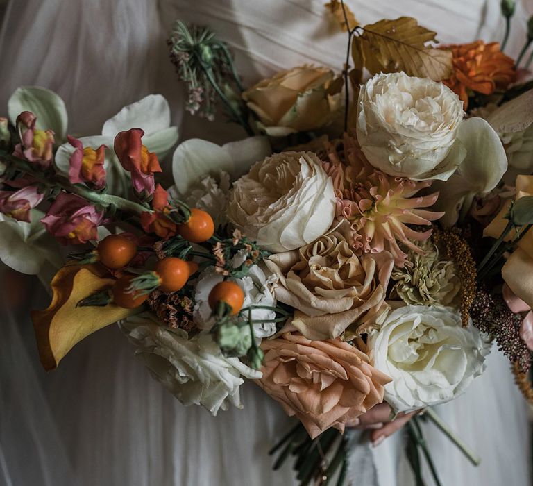 Pink and white peony and rose wedding bouquet with autumnal leaves for September wedding 