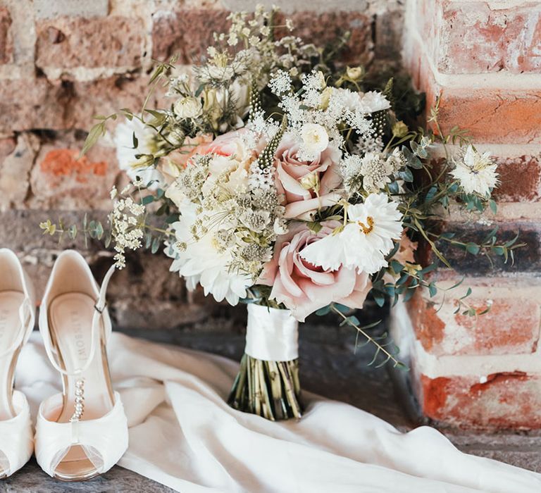 Rainbow wedding shoes with pretty bow detail with the bride's pink and white bouquet with roses and cosmos 