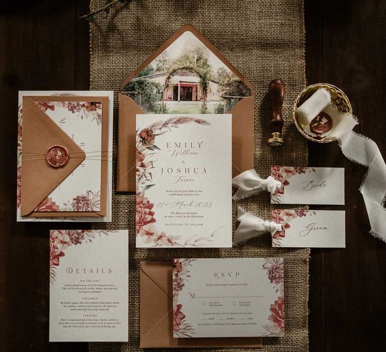 Botanical luxe wedding stationary with brown envelopes with watercolour paintings on mahogany table