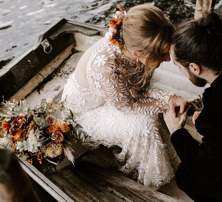 The bride and groom hold hands and rest their foreheads against each other in special intimate moment together