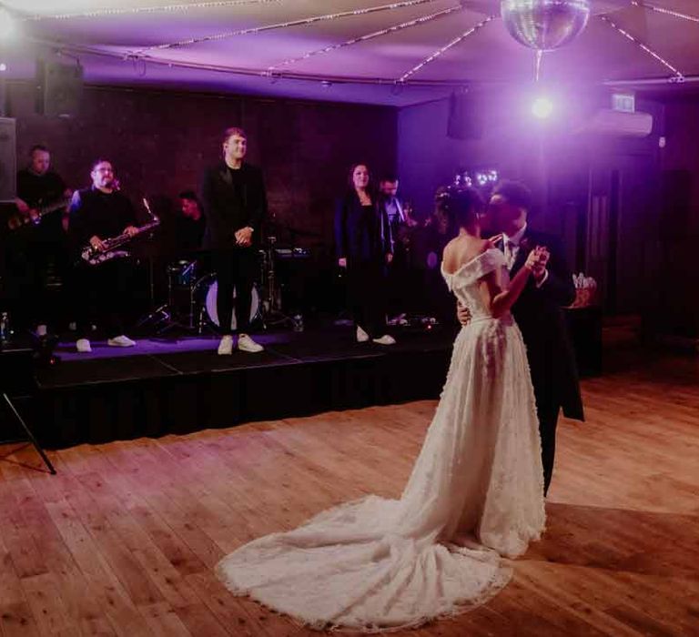 Bride in Suzanne Neville off shoulder 3D floral applique wedding dress with puddle train doing wedding first dance with groom in navy groom morning suit at Elmore Court Gloucestershire 