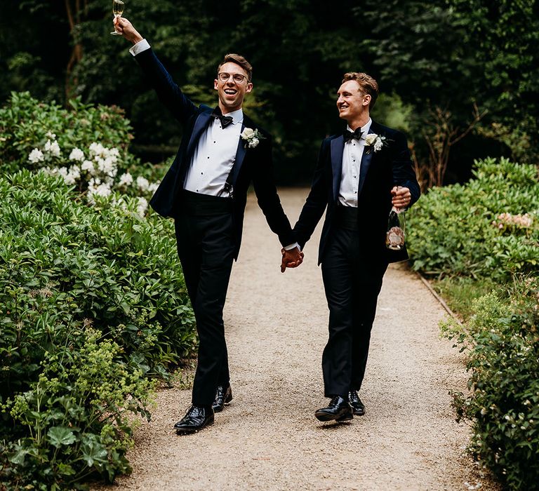 Couples portrait of two grooms in blue tuxedos at Deer Park wedding venue 