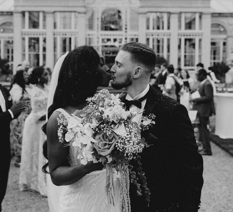 Syon Park wedding venue with the bride and groom sharing a kiss after their confetti exit 