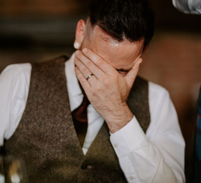 Groom hides his face as he reacts to the wedding speeches 