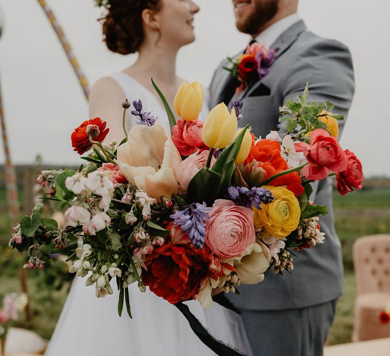 Pink, purple, and yellow tulip wedding bouquet for boho colourful festival wedding 