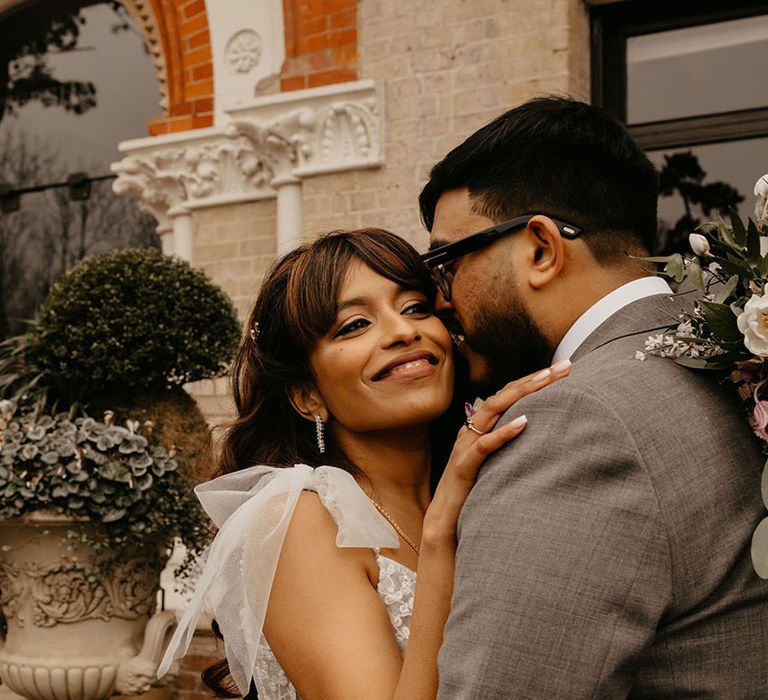 Multicultural wedding with the bride wearing a lace wedding dress with tulle bow straps 