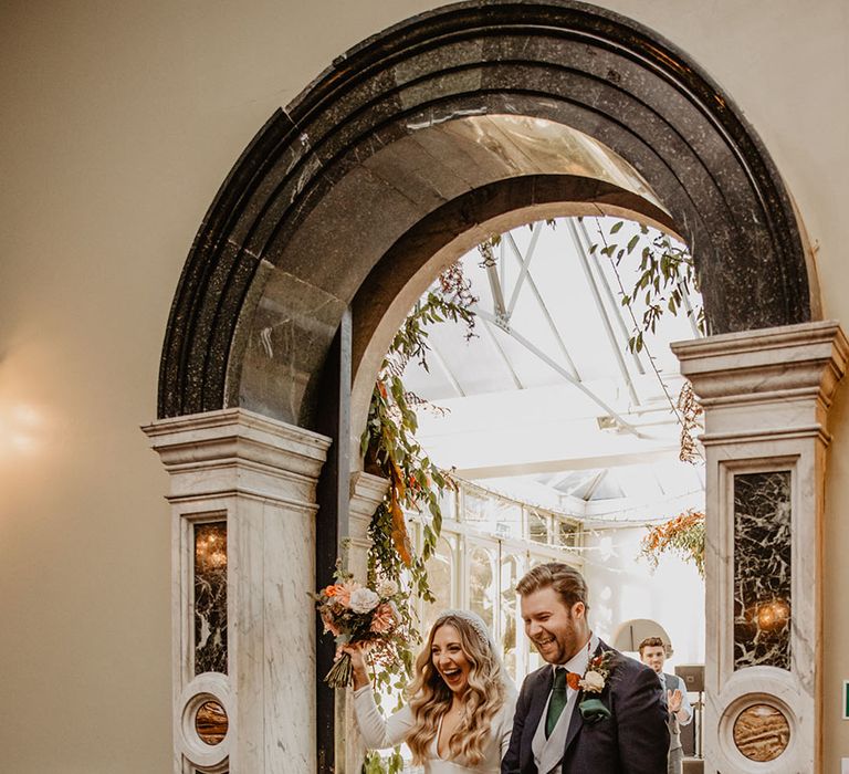 Hampton Court House wedding with bride and groom entering their wedding reception 