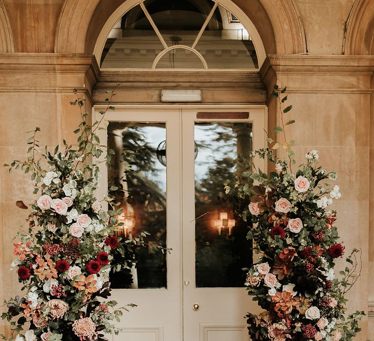 Pale pink and red autumnal wedding flower column decorations 