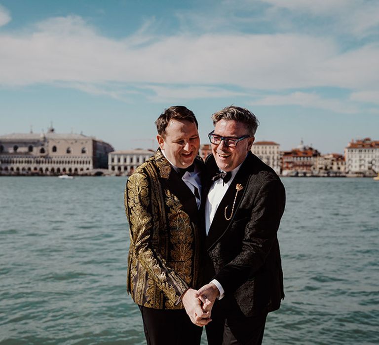 Venice destination wedding with two grooms dancing together overlooking the view 