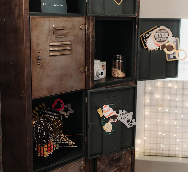 Photo booth props in industrial style lockers for the guests to take photos with for the guest book 