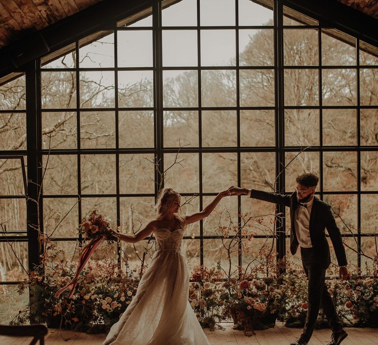 Bride and groom dancing in front of the crittal windows at The Hidden River Cabins 