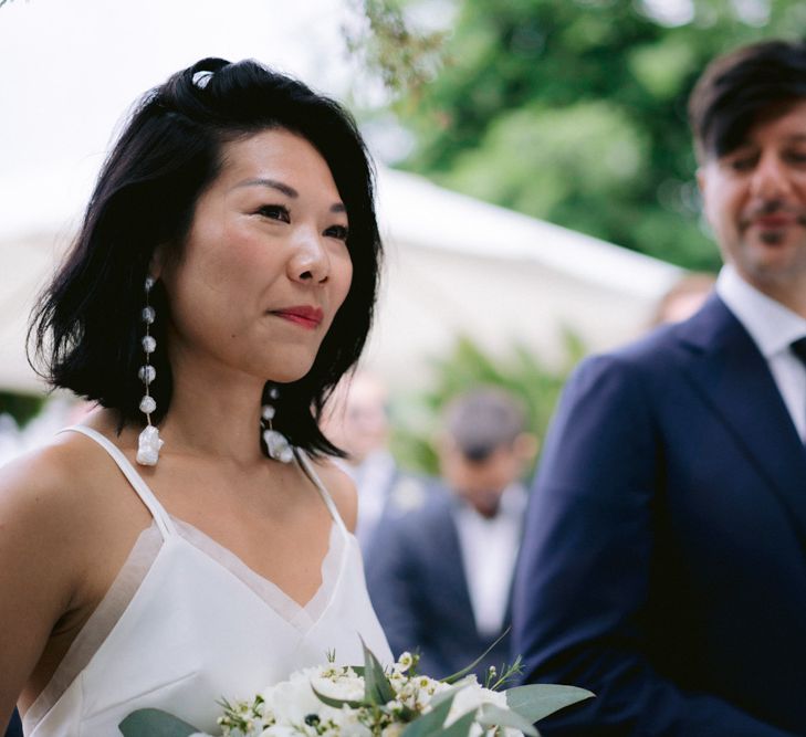 Bride in cami top and dangly earrings. 