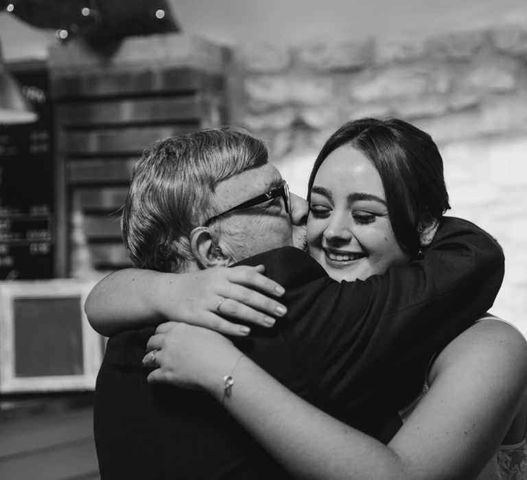 Smiling bride hugging a wedding guest