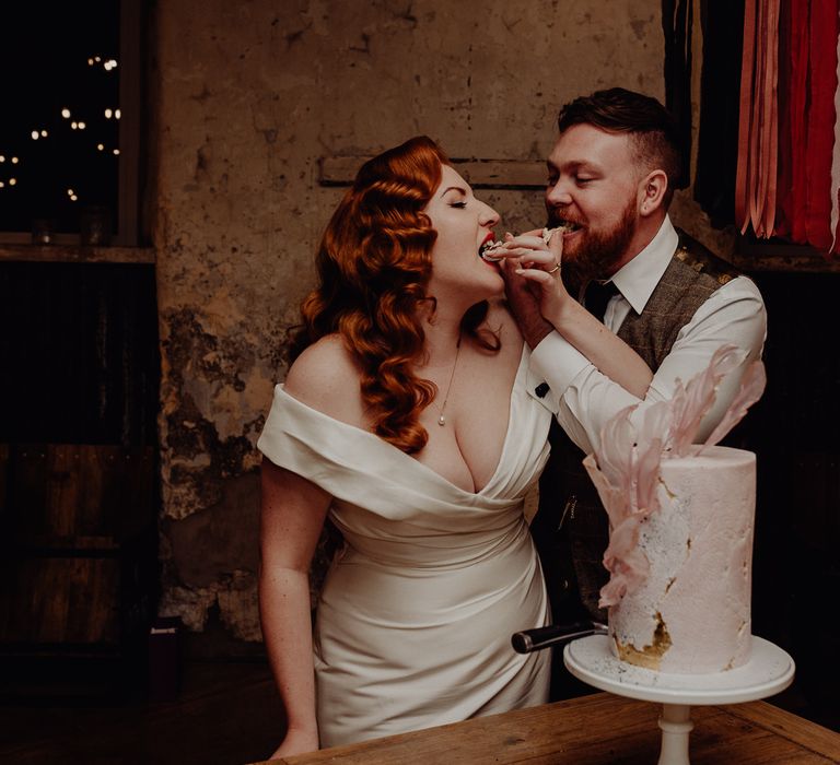 Bride and groom feeding cake to each other at their Micro wedding 