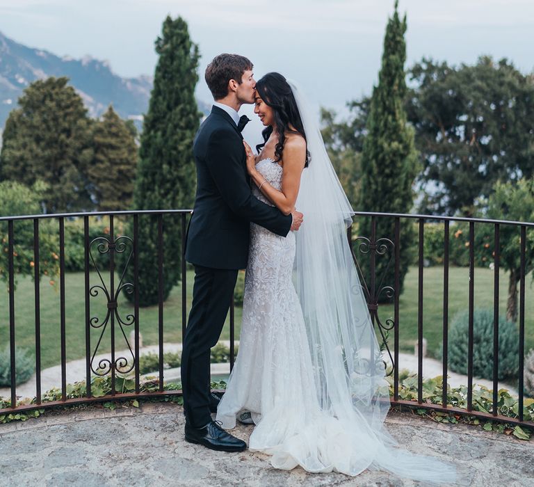 Groom in tuxedo kissing his brides forehead at Ravello wedding