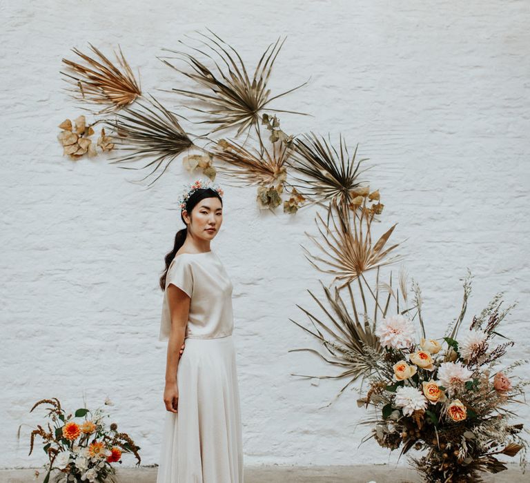 The bride wearing a two piece wedding dress of silk top and flowing skirt